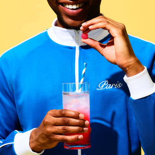 Man holding Vitawell gummies and drink