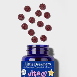 Blue bottle of 'Little Dreamers' with red chewable gummies on a light grey background