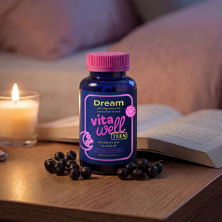 Bottle of 'Dream vitawell TEEN' on a table with candles and books in the background