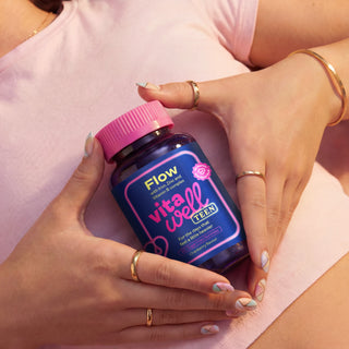 Person holding a bottle of Flow Vitawell Teen vitamins with a pink cap 