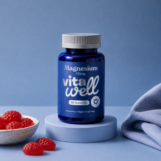 Blue bottle of 'Vitawell' magnesium gummies with strawberries on a blue background